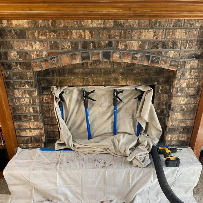 Fireplace draped with protective covering during a chimney sweep service