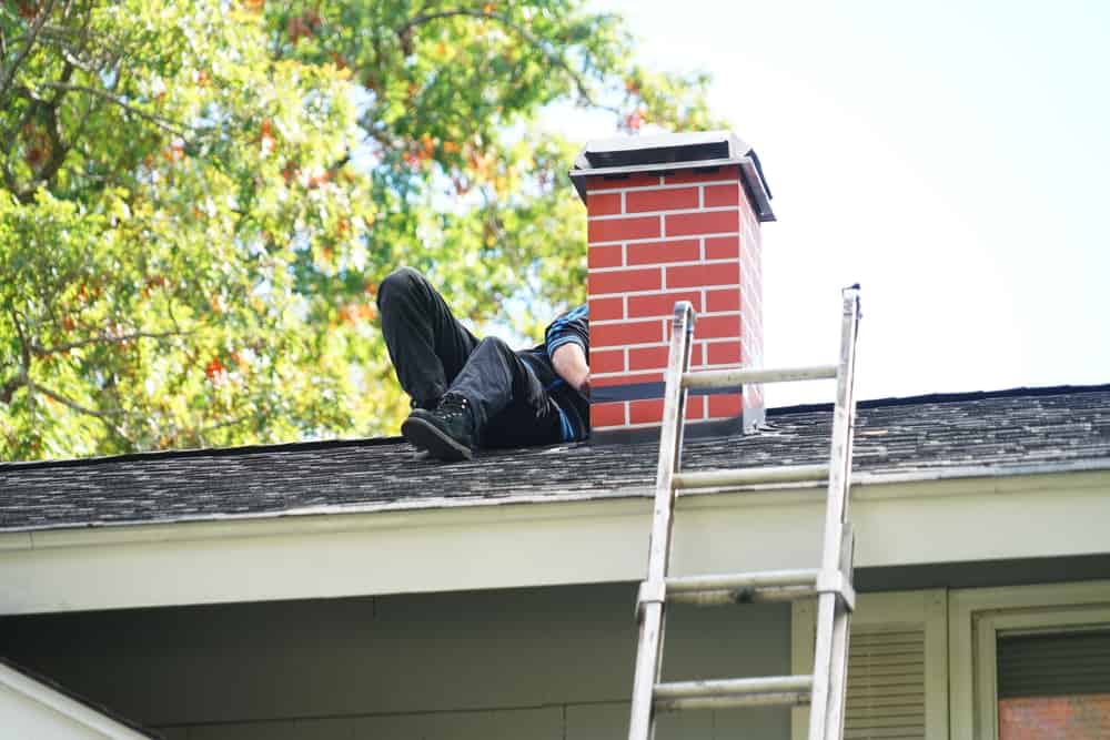 Worker,Repairing,Chimney,On,The,Roof