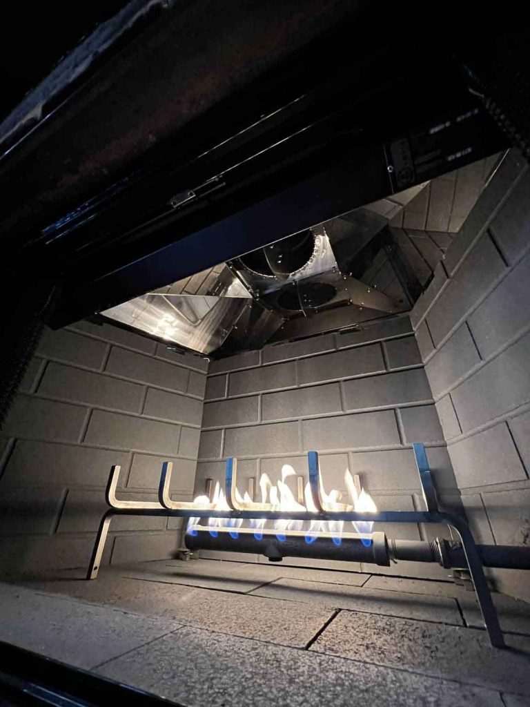 A gas fireplace burning fire during a chimney sweep and inspection service