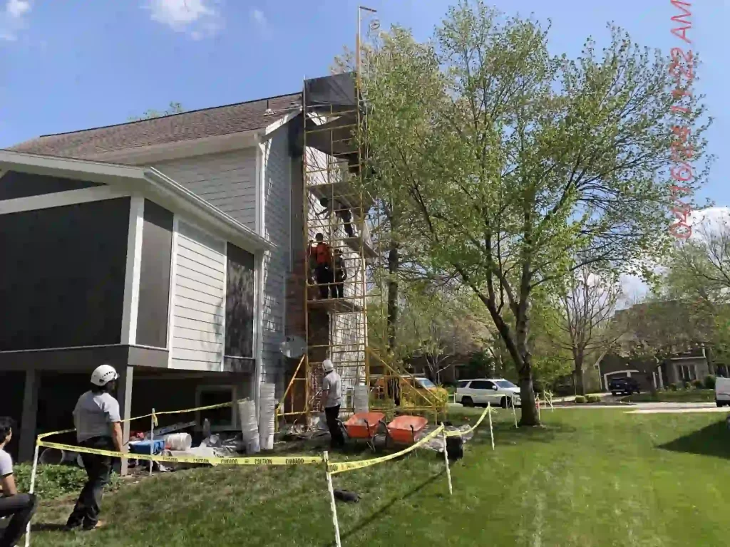 Chimney Restoration of Kansas City professionals performing maintenance on the chimney top to ensure optimal performance.