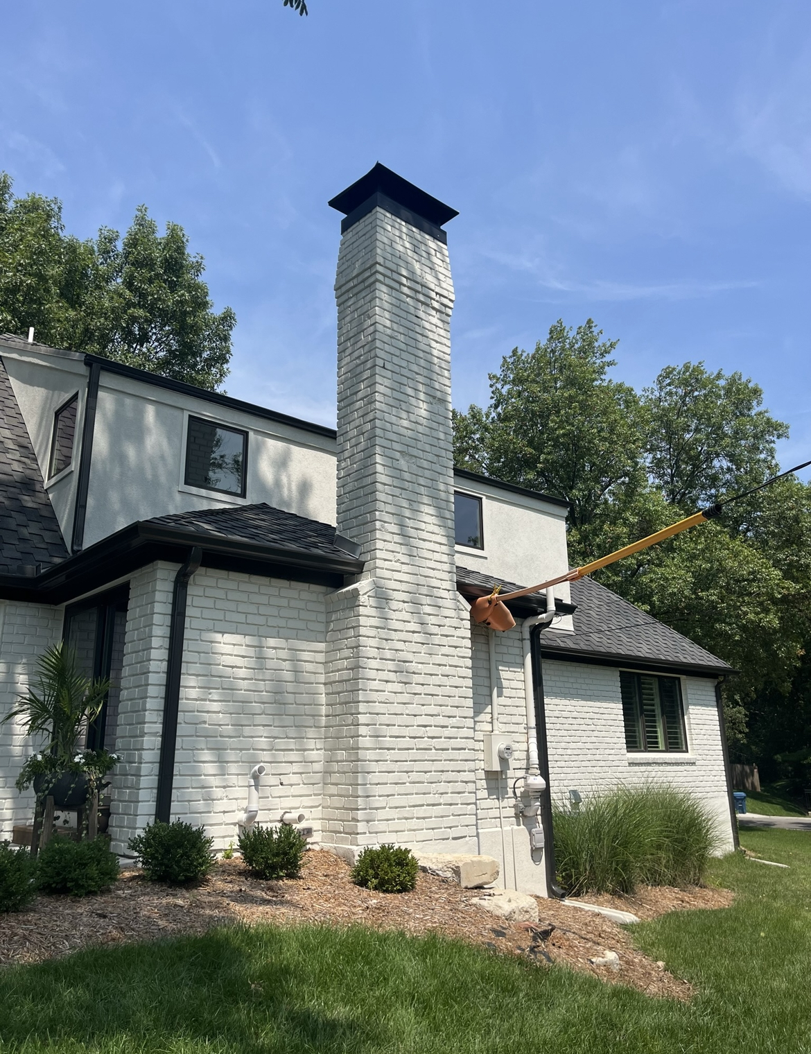White brick chimney on Kansas City home after chimney repairs and chimney cap installation