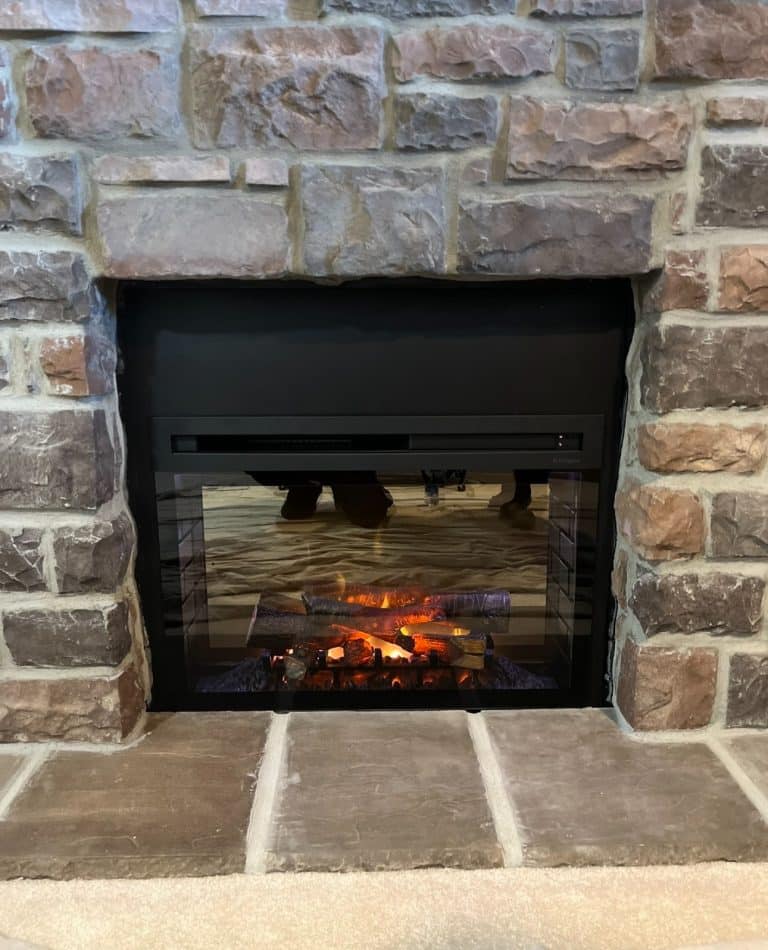 Linear gas fireplace insert installed inside existing stone masonry fireplace in Leawood Kansas home by Chimney Restoration of KC Team