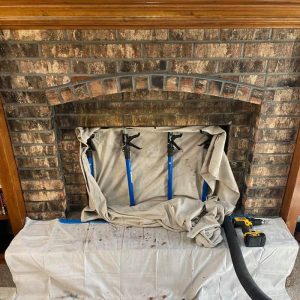 Fireplace draped with protective covering during a chimney sweep service in Kansas City