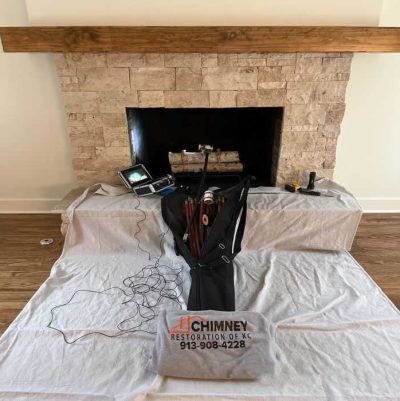 Kansas City Chimney Sweep Poles & Camera Chimney Inspection equipment near fireplace CSIA certified technician performing chimney sweep in Kansas City home