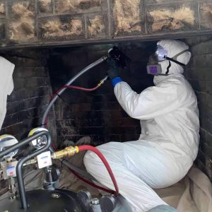 tech performing a fireplace inspection and cleaning in Kansas City home