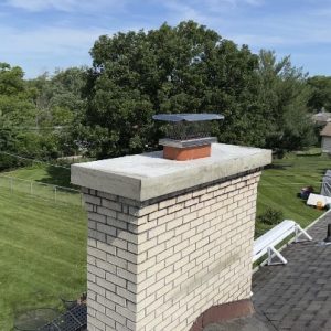 Professional chimney sweep cleaning soot and debris from a residential chimney in Leawood, KS.