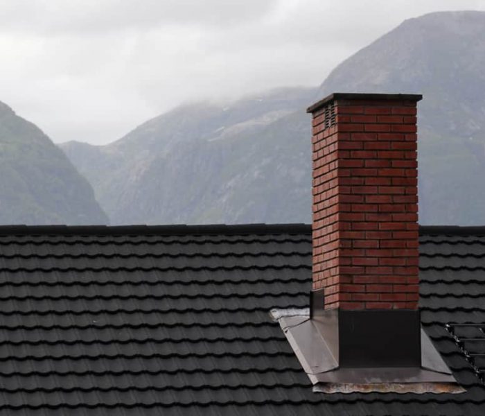 Chimney,On,A,Roof,In,A,Mountain,Area,During,Inclement