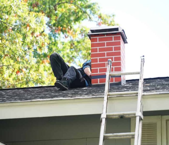 Worker,Repairing,Chimney,On,The,Roof